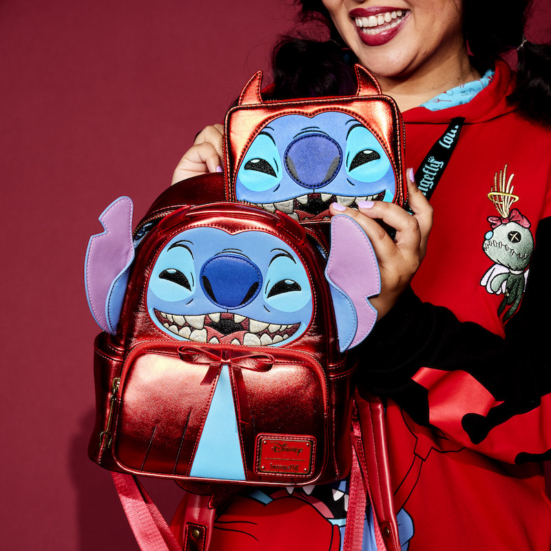 Woman wearing the Devil Stitch Hoodie holding the Devil Stitch Mini Backpack and the Devil Stitch Wallet 